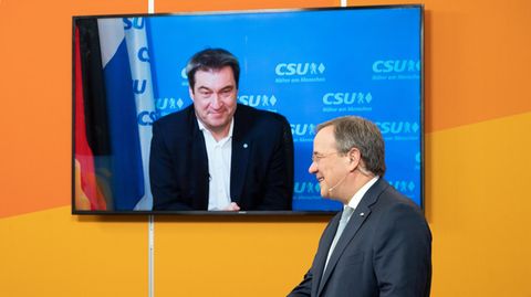 Der CDU-Parteivorsitzende Armin Laschet steht im Anzug an einem Rednerpult mit CDU-Logo, ein TV-Gerät im Hintergrund zeigt Söder