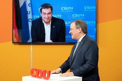 Der CDU-Parteivorsitzende Armin Laschet steht im Anzug an einem Rednerpult mit CDU-Logo, ein TV-Gerät im Hintergrund zeigt Söder