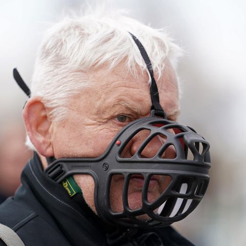 Ein weißhaariger älterer Mann trägt statt einer FFP2-Maske einen schwarzen Maulkorb für Hunde