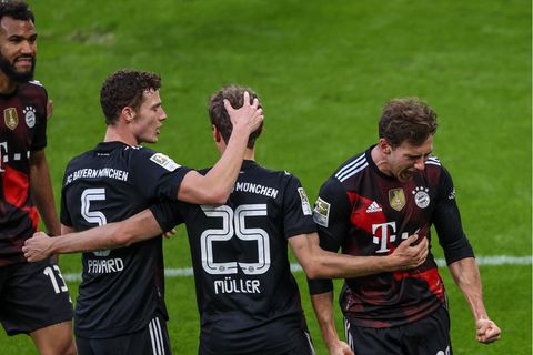 Vier Spieler des FC Bayern München jubeln auf dem Rasen des Bundesliga-Stadions in Leipzig