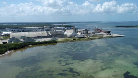 Am Ufer eines Sees ist eine riesige Fabrik zu sehen