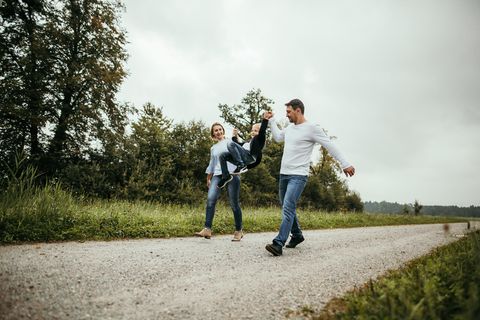 Eltern läuft mit Kind an der Hand durch ein Feld