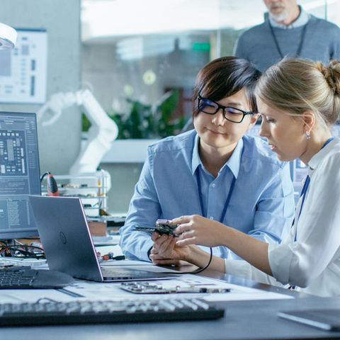 Zwei Frauen bei der Reparatur eines Laptops. Ein Feld zur Passwort-Eingabe ist nicht zu sehen