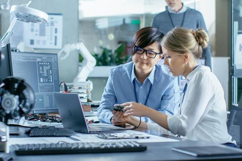 Zwei Frauen bei der Reparatur eines Laptops. Ein Feld zur Passwort-Eingabe ist nicht zu sehen