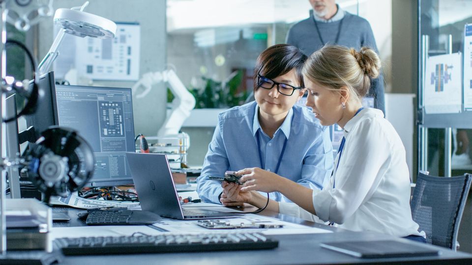 Zwei Frauen bei der Reparatur eines Laptops. Ein Feld zur Passwort-Eingabe ist nicht zu sehen