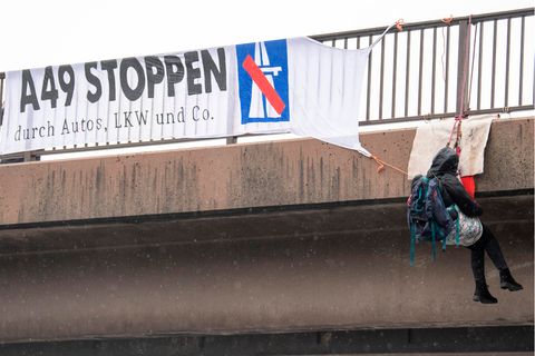 Gegner des Ausbaus der A49 haben sich von einer Brücke über die Autobahn 5 am Flughafen Frankfurt abgeseilt