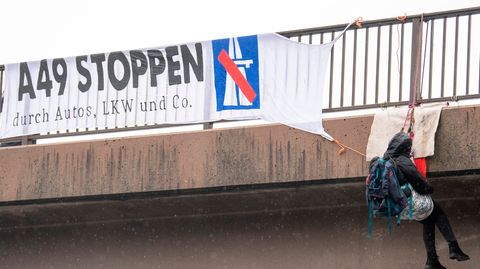 Gegner des Ausbaus der A49 haben sich von einer Brücke über die Autobahn 5 am Flughafen Frankfurt abgeseilt