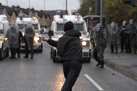 Ein Demonstrant attackiert Polizeibeamte in Nordirlands Hauptstadt Belfast
