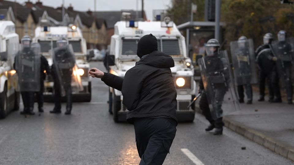 Ein Demonstrant attackiert Polizeibeamte in Nordirlands Hauptstadt Belfast