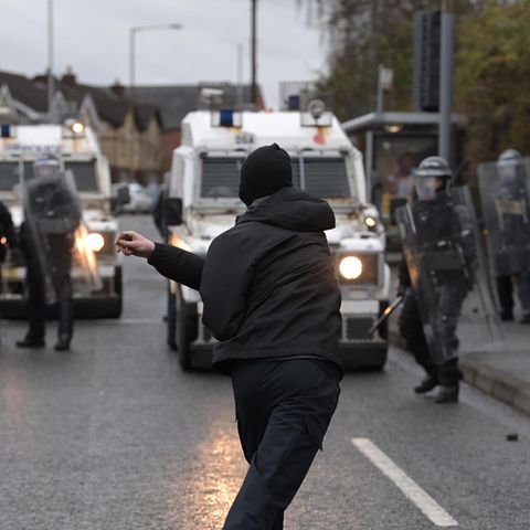 Ein Demonstrant attackiert Polizeibeamte in Nordirlands Hauptstadt Belfast