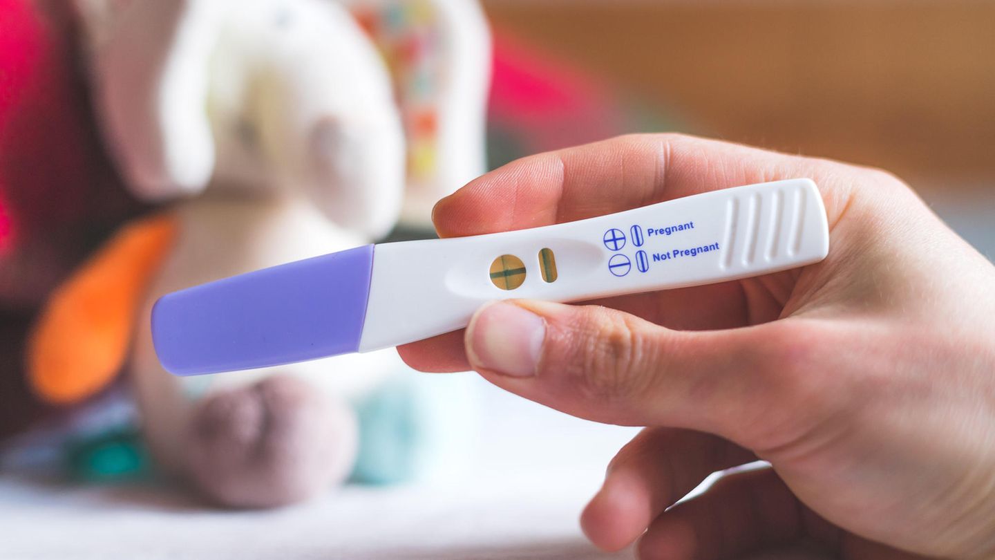 Eine Hand zeigt einen positiven Schwangerschaftstest