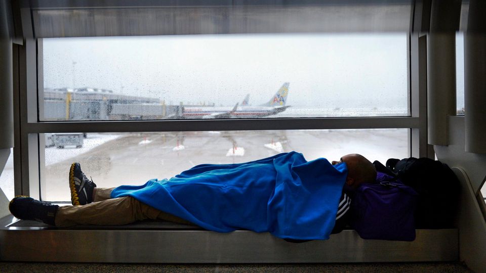 Ein Mann macht ein Nickerchen auf dem Airport in Arlington, Virginia, USA.