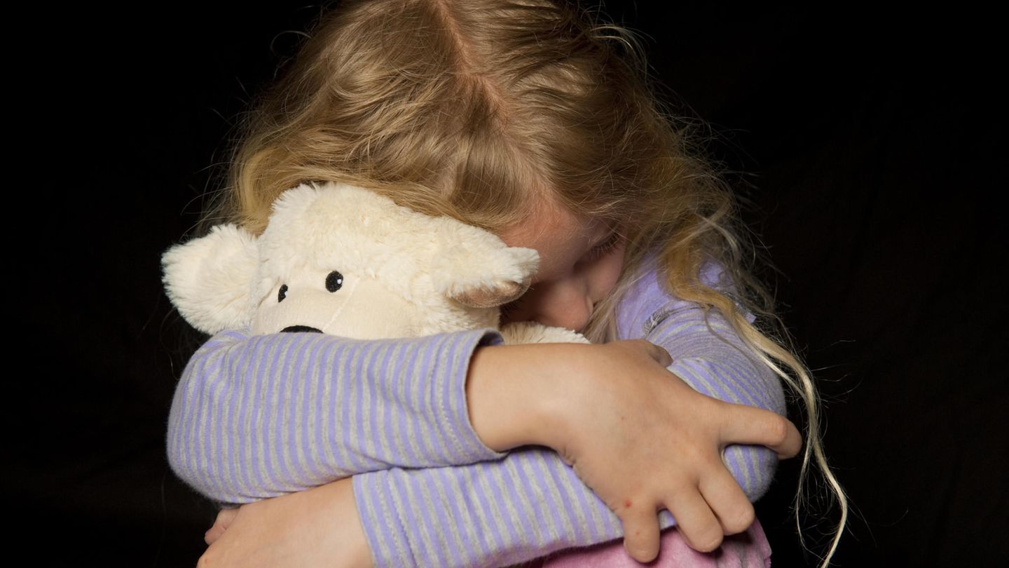 Kind umklammert ein Kuscheltier.