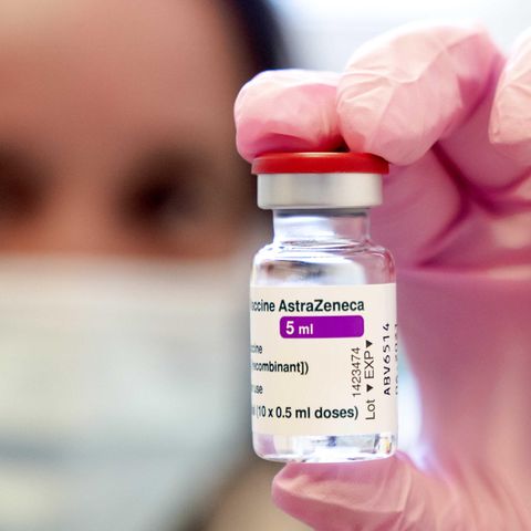 Eine Person hält eine Ampulle des Impfstoffs von Astrazeneca in die Kamera.