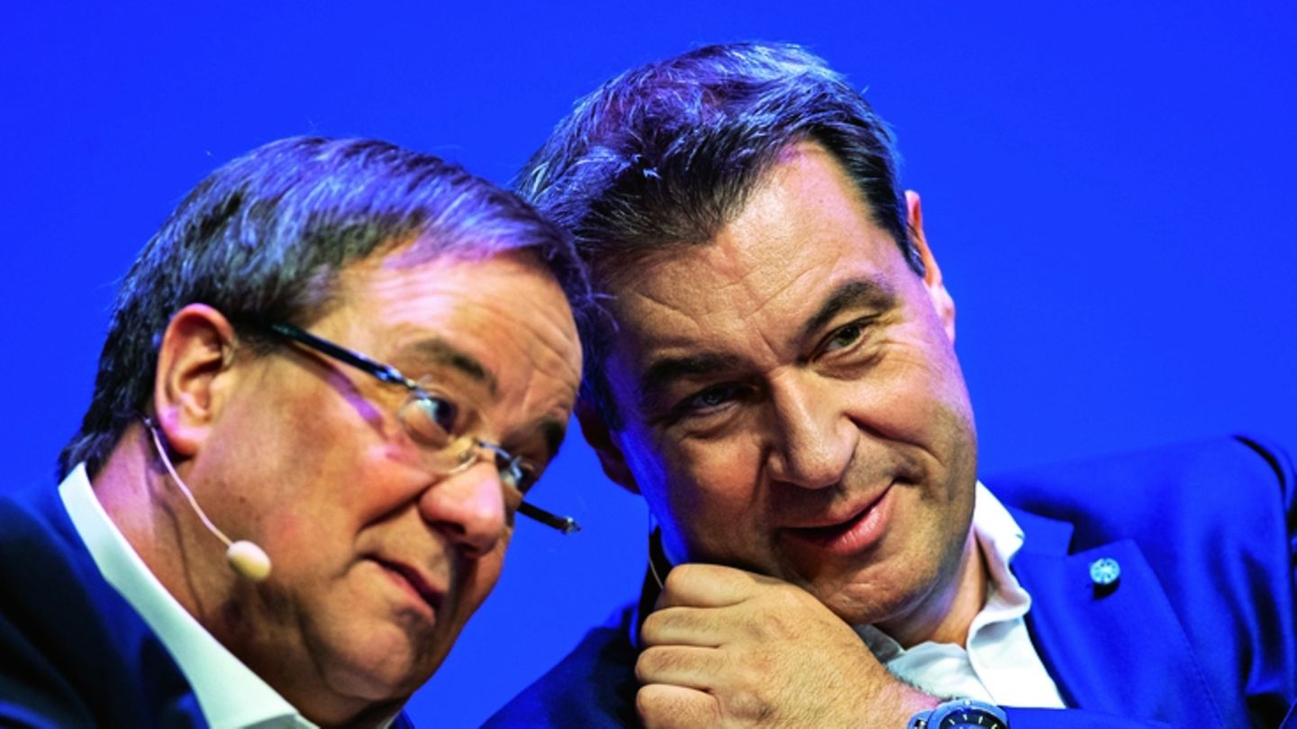 Armin Laschet neben Markus Söder vor einem blauen Hintergrund
