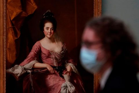 Eine Besucherin mit Maske steht vor einem Gemälde im Metropolitan Museum of Art