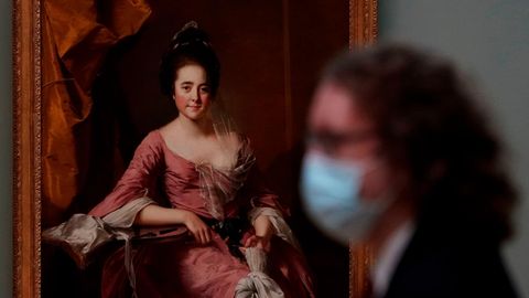 Eine Besucherin mit Maske steht vor einem Gemälde im Metropolitan Museum of Art