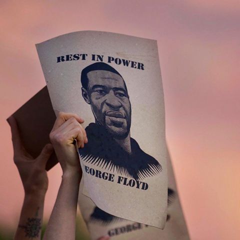 Demonstranten in Minneapolis halten während einer Protestaktion Plakate mit dem Porträt von George Floyd in die Höhe.
