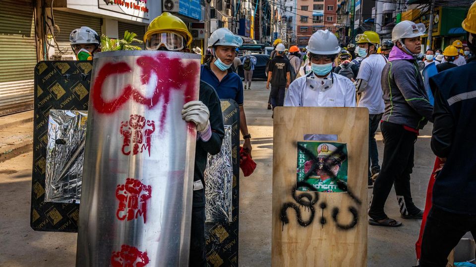 Anti-coup protesters with homemade shields and block the street to defend themselves from the security forces crackdown during peaceful protest in Yangon, Myanmar on March 3, 2021. Das Bild des verhassten Putsch-Anführers ist durchgestrichen: Mit selbst gemachten Schilden verteidigen sich Demonstranten
