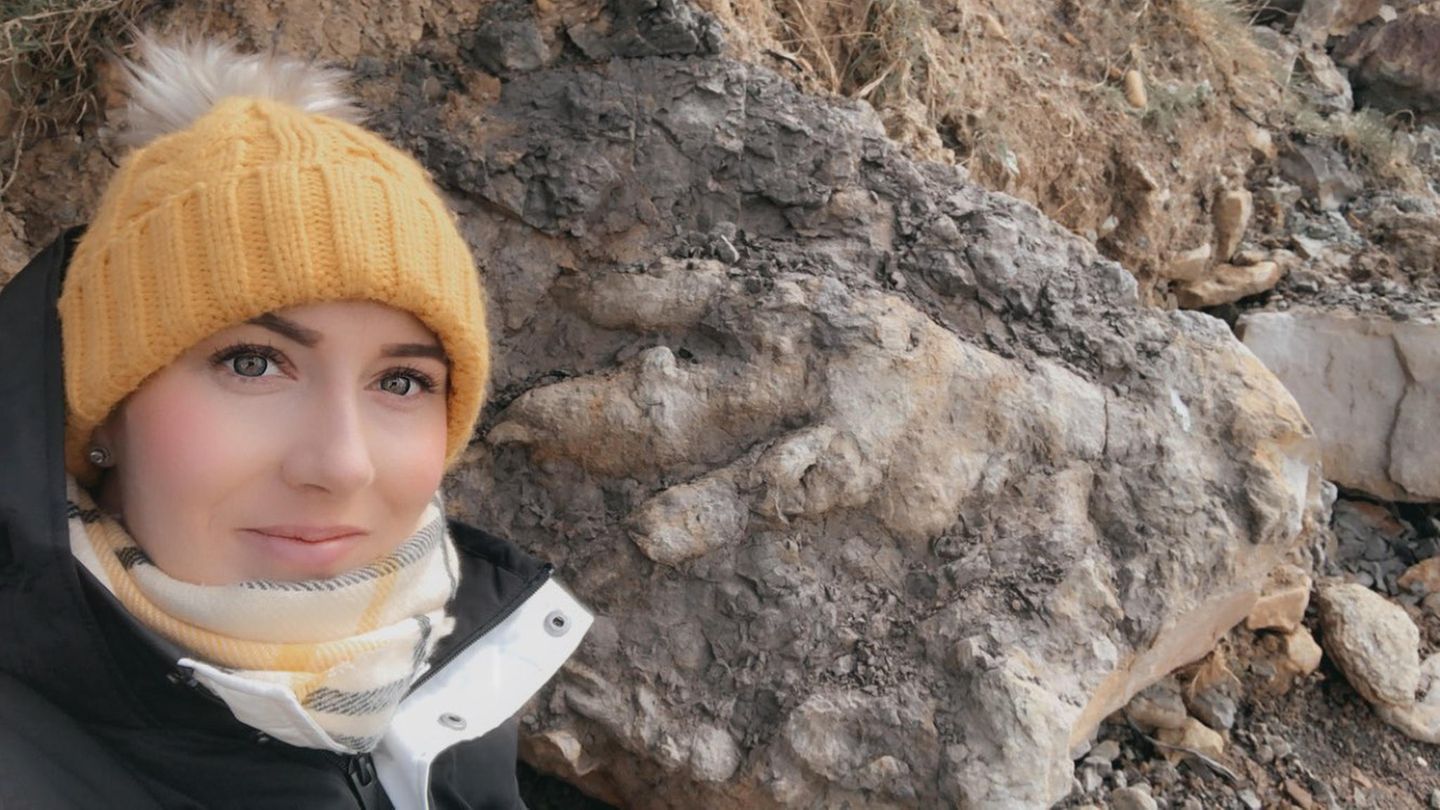 Die Archäologin Marie Woods mit dem Dinosaurier-Fußbadruck im Hintergrund
