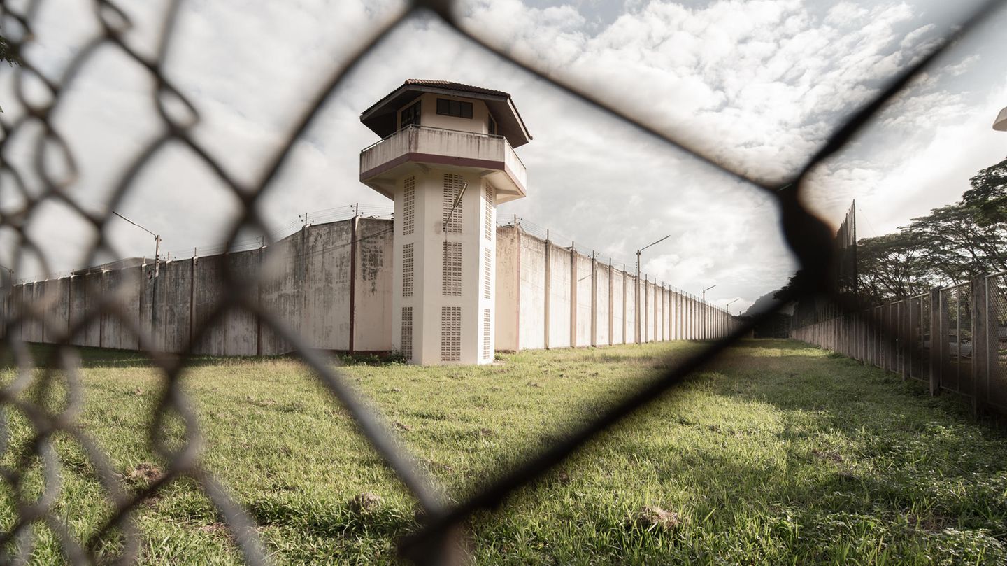 Blick auf Gefängnisturm durch Maschendrahtzaun