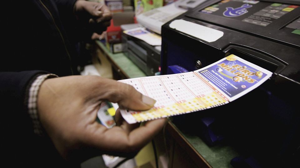 Ein Kunde führt seinen Lottoschein in ein Lesegerät