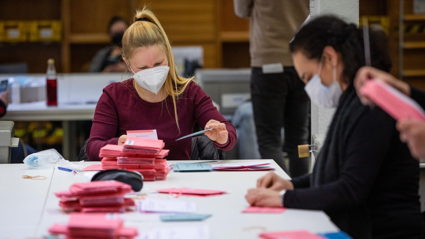 Wahlhelferinnen und Wahlhelfer kontrollieren Stimmzettel.