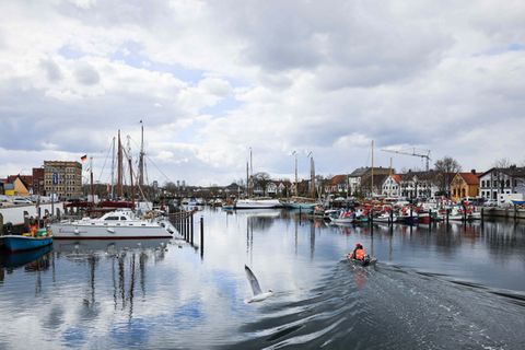 Zwei Angler fahren auf einem Bott durch den Hafen von Eckernförde.