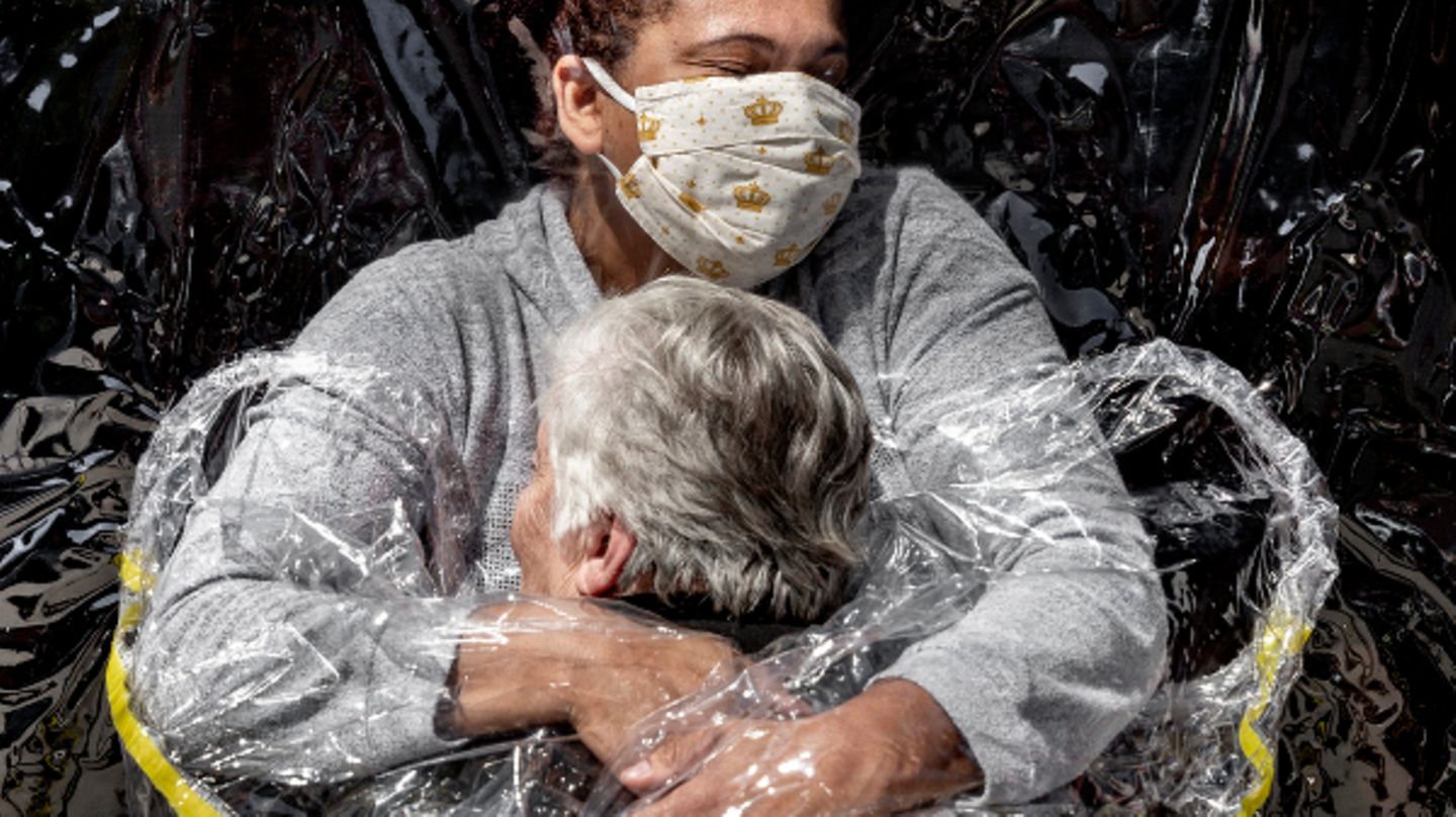 Die erste Umarmung seit fünf Monaten durch einen Plastikvorhang