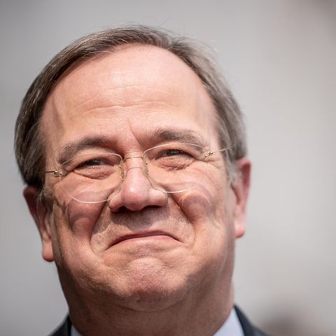 Ein älterer weißer Mann mit randloser Brille und dunkelgrauem Seitenscheitel lächelt, während ihm die Sonne ins Gesicht scheint