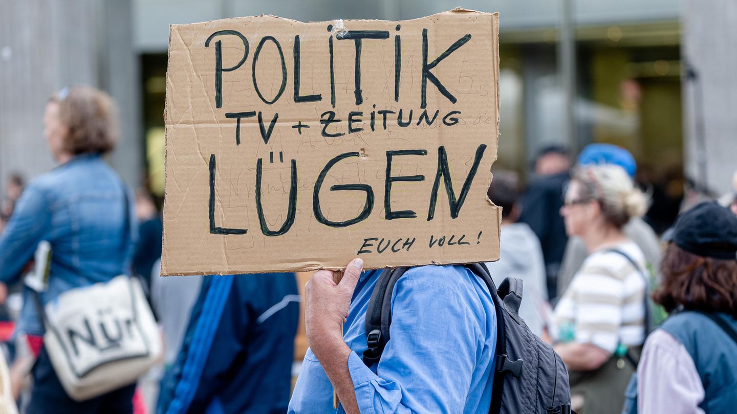 Ein Mann hält ein Plakat während einer Demonstration in Hamburg gegen die Corona-Maßnahmen