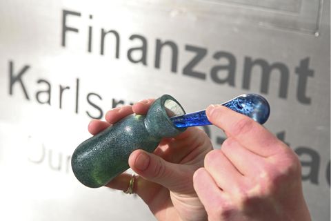 Vor dem Finanzamt Karlsruhe Stadt wird ein Flacon mit dem Parfüm Aerarium gezeigt
