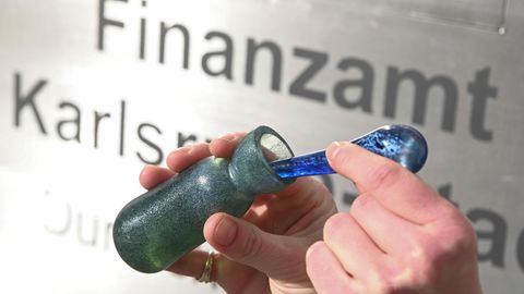 Vor dem Finanzamt Karlsruhe Stadt wird ein Flacon mit dem Parfüm Aerarium gezeigt