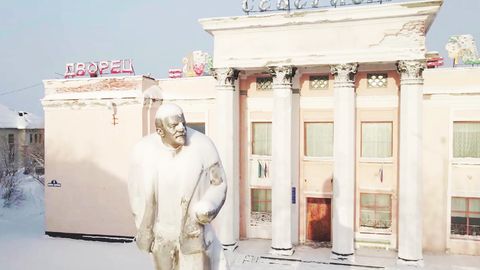 Von Schnee bedeckte Statue in einer verlassenen russischen Stadt