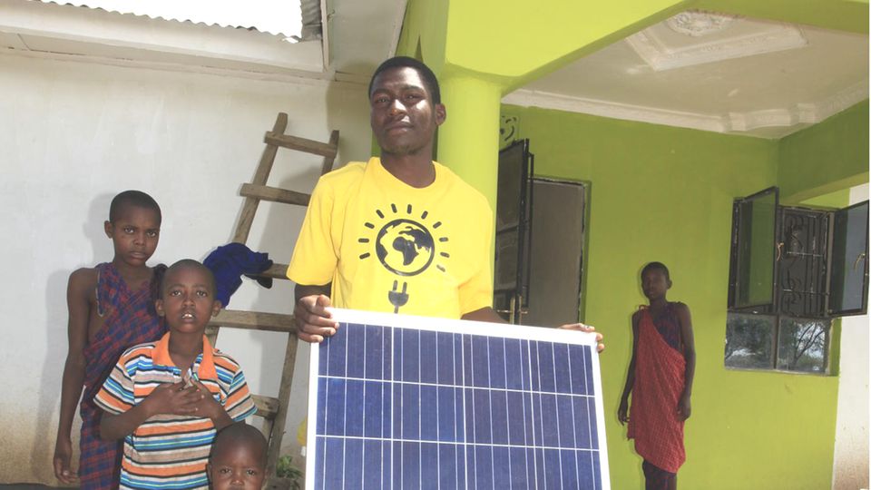 Eine Familie aus der Nähe von Arusha nimmt ihre neue Solaranlage in Empfang