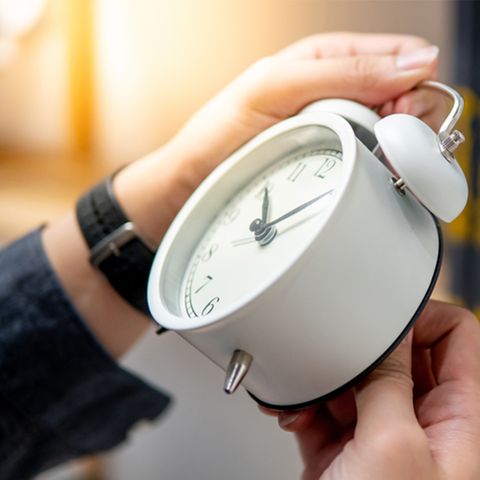 Person hält eine Uhr