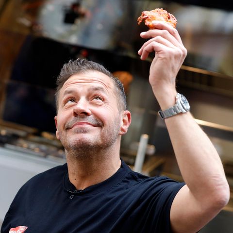 Willi Herren hält in Köln einen Reibekuchen in der Hand