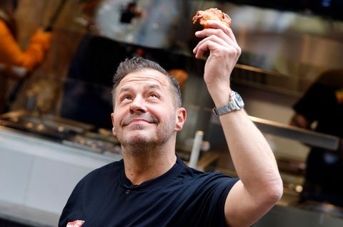 Willi Herren hält in Köln einen Reibekuchen in der Hand