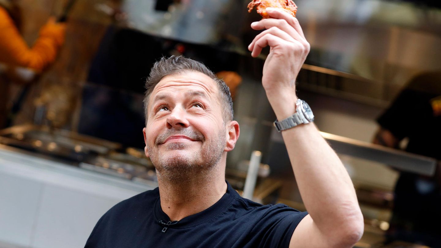Willi Herren hält in Köln einen Reibekuchen in der Hand