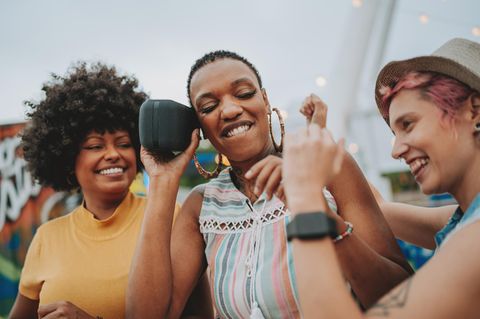 Outdoor-Lautsprechern: Junge Menschen hören Musik über den Lautsprecher