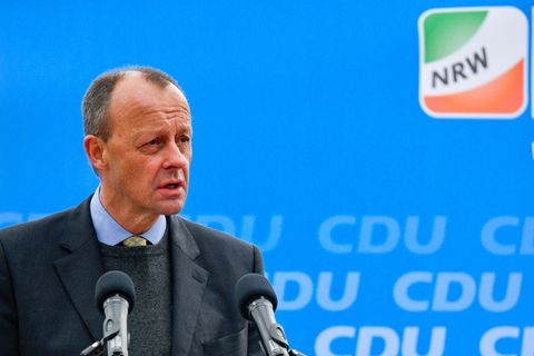 Ein weißer Mann mit kurzen braunen Haaren spricht vor einer blauen Wand mit CDU NRW Logo in zwei Mikrofone