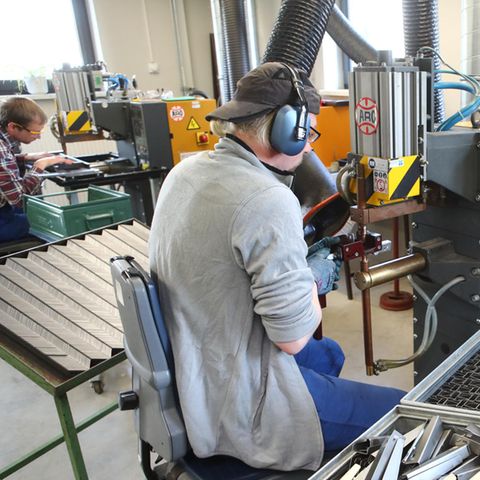 Zwei Personen arbeiten in einer Werkstatt für Menschen mit Behinderung