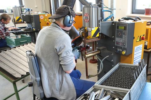 Zwei Personen arbeiten in einer Werkstatt für Menschen mit Behinderung