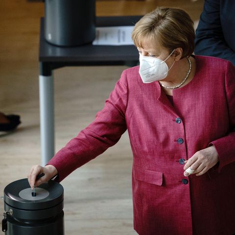 Bundeskanzlerin Angela Merkel (CDU) steckt ihre Stimmkarte bei der Sitzung des Bundestags in die Wahlurne