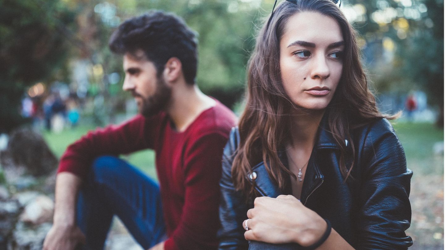 Pärchen sitzt nebeneinander und dreht sich voneinander weg
