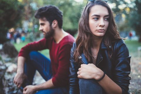Pärchen sitzt nebeneinander und dreht sich voneinander weg