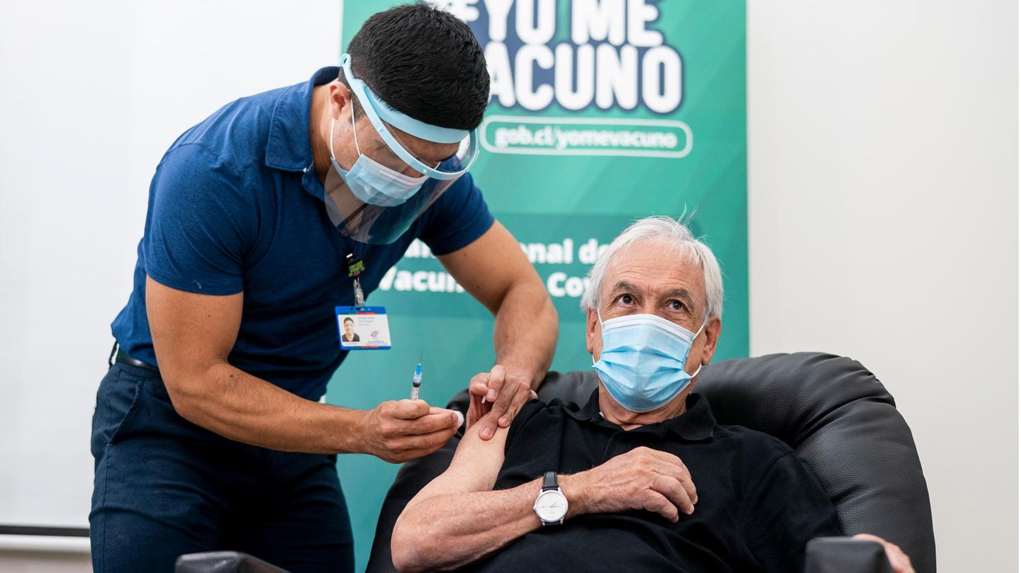 Eine Pflegekraft impft den chilenischen Präsidenten Sebastián Piñera.