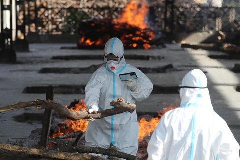 Indien: Ein Familienmitglied eines Corona-Toten vollzieht in einem Krematorium dessen letzte Ölung