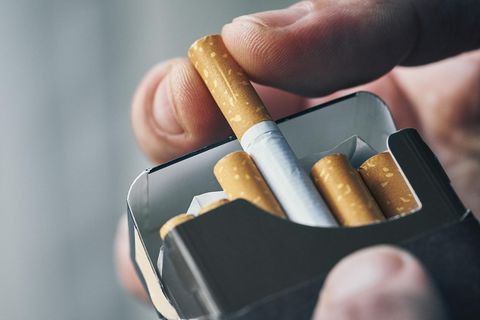 Mann holt Zigarette aus der Schachtel