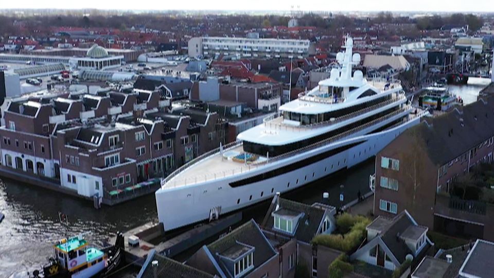 Schlepper ziehen riesige Luxus-Jacht durch winzige Kanäle in den Niederlanden